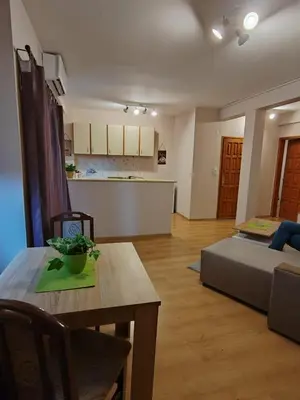 a living room with a table and a bed and a kitchen at Stella Apartment in Karaburma
