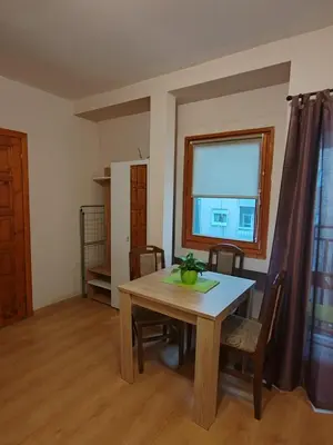 a dining room with a table and chairs and a window at Stella Apartment in Karaburma