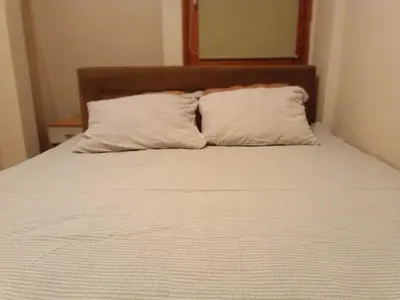 a bed with two pillows on top of it at Stella Apartment in Karaburma