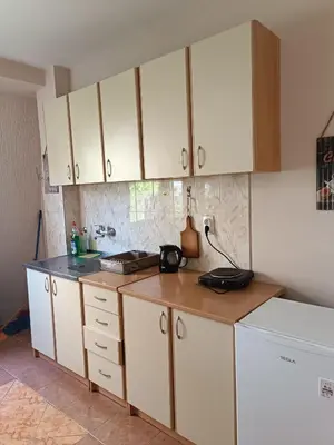 a kitchen with white cabinets and a counter top at Stella Apartment in Karaburma