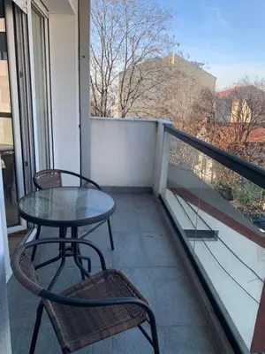 a table and chairs on a balcony with a view at Vanja's place in Belgrade