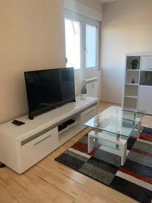 a living room with a flat screen tv on a white entertainment center at Vanja's place in Belgrade