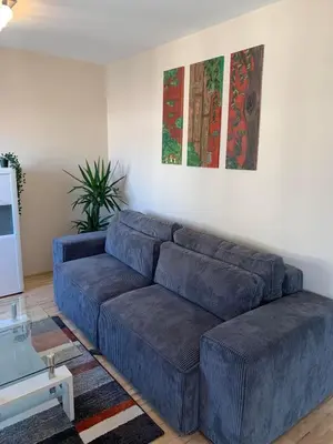 a living room with a blue couch in a room at Vanja's place in Belgrade