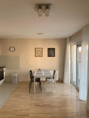 a kitchen and dining room with a table and chairs at Vanja's place in Belgrade