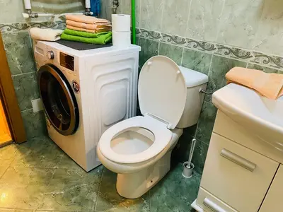 a bathroom with a toilet and a washing machine at Jolly Apartment - Belgrade in Belgrade