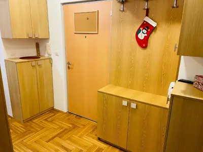 a kitchen with wooden cabinets and a door in a room at Jolly Apartment - Belgrade in Belgrade