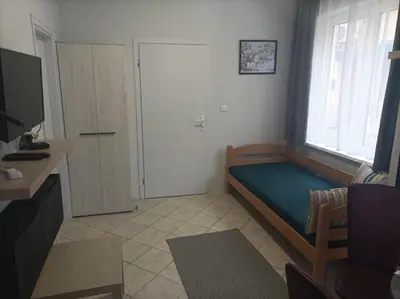 a small bedroom with a bed and a window at Katera in Belgrade