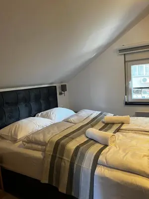 a bedroom with two beds and a window at Ortak Apartments in Belgrade