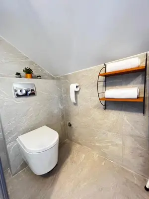 a bathroom with a toilet and towels on the wall at Ortak Apartments in Belgrade