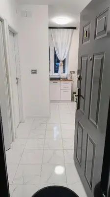a kitchen with a door and a white tile floor at TALIJA in Vračar (historical)