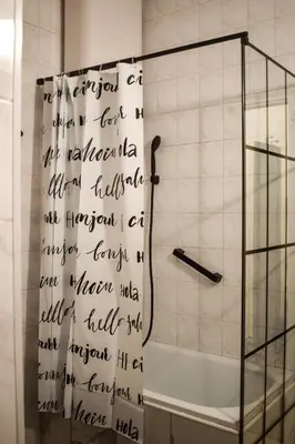 a bathroom with a shower with writing on the wall at Lana's home in the best part of the city in Vračar (historical)