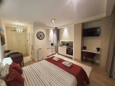a bedroom with a large bed and a kitchen at Belgrade Waterfront Apartment - Beograd na vodi in Belgrade