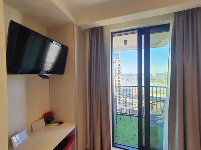 a hotel room with a flat screen tv and a window at Belgrade Waterfront Apartment - Beograd na vodi in Belgrade