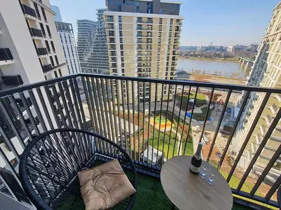 a balcony with a table and a view of a city at Belgrade Waterfront Apartment - Beograd na vodi in Belgrade