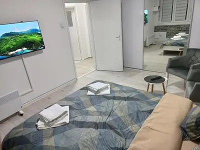 a living room with a couch and a tv on a wall at Savska - Apartment in Sajmište