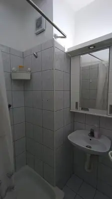 a white bathroom with a sink and a mirror at Savska - Apartment in Sajmište