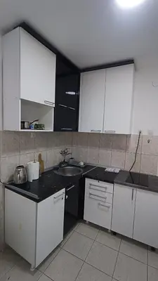 a kitchen with white cabinets and a sink at Savska - Apartment in Sajmište