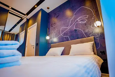 a bedroom with a large bed with a purple wall at Miha Premium Apartment in Belgrade