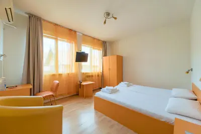 a hotel room with a bed and a chair at Hotel Villa Sarto in Belgrade