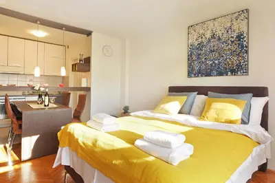 a large yellow bed in a room with a kitchen at Apartment Paradise Serenity in Belgrade
