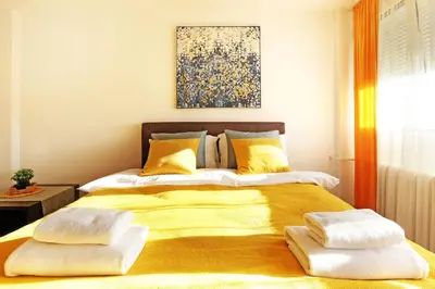 a bedroom with a large yellow bed with two pillows at Apartment Paradise Serenity in Belgrade