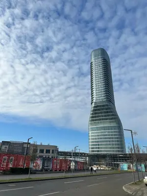 a tall glass building sitting on the side of a street at Skyway Apartment Belgrade Waterfront in Belgrade