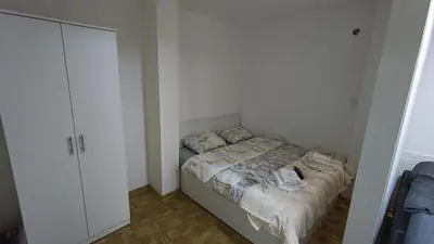 a small bedroom with a bed and a cabinet at Trgovacka Zarkovo - Apartman in Žarkovo