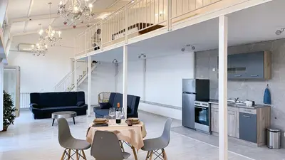 a living room with a table and chairs and a kitchen at Tiffany Belgrade apartment in Belgrade