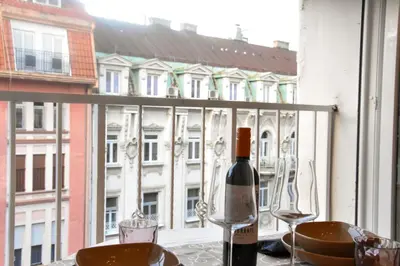 a bottle of wine sitting on a table in front of a window at Tiffany Belgrade apartment in Belgrade