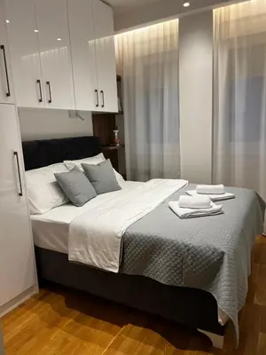 a bedroom with a large bed with towels on it at Real Apartment Banovci in Novi Banovci