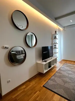 a living room with two mirrors and a television at Real Apartment Banovci in Novi Banovci