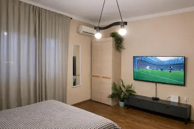 a bedroom with a flat screen tv on the wall at Little L Apartment Obilic in Belgrade