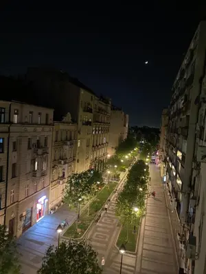 a city street at night with buildings and street lights at Little L Apartment Obilic in Belgrade