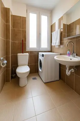 a bathroom with a toilet and a sink and a washing machine at Little L Apartment Obilic in Belgrade