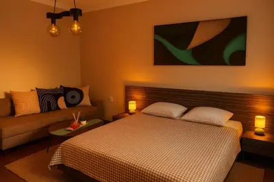 a bedroom with a bed and a couch at Little L Apartment Obilic in Belgrade