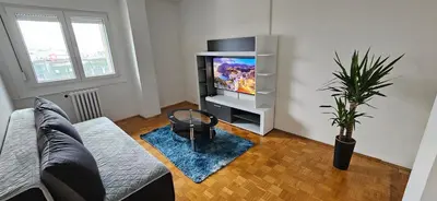 a living room with a couch and a tv at 3-rooms Arena apartment in Belgrade