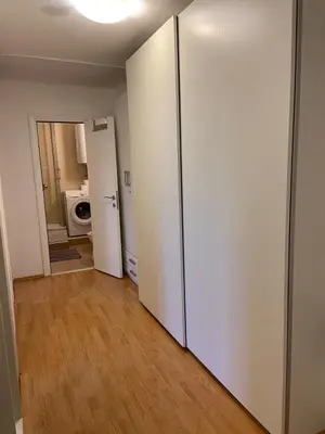 an empty room with a white refrigerator in a room at 3-rooms Arena apartment in Belgrade