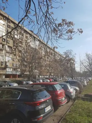 a parking lot with cars parked in front of a building at 3-rooms Arena apartment in Belgrade