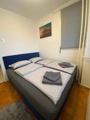 a bedroom with a bed with two towels on it at 3-rooms Arena apartment in Belgrade