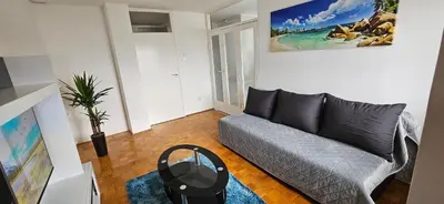 a living room with a couch and a painting on the wall at 3-rooms Arena apartment in Belgrade