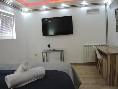 a bedroom with a bed and a flat screen tv on the wall at Rooms&Restaurant 43 in Belgrade