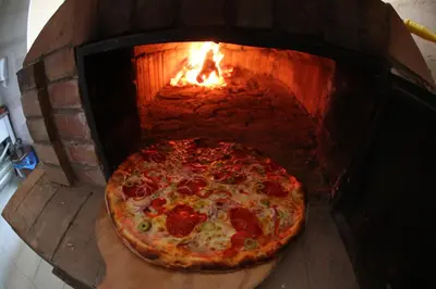 a pizza is being cooked in a brick oven at Rooms&Restaurant 43 in Belgrade