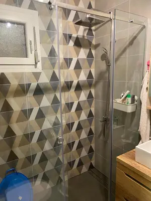 a shower with a glass door in a bathroom at Kućica u šumici in Stojnik