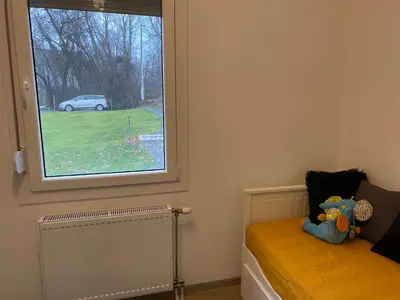 a room with a window and a bed with a toy at Kućica u šumici in Stojnik