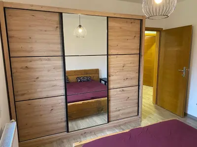 a large wooden cabinet with a purple bed in a room at Kućica u šumici in Stojnik
