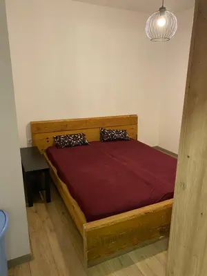 a bedroom with a wooden bed in a room at Kućica u šumici in Stojnik