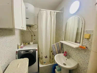 a small bathroom with a sink and a shower at Funkcionalna garsonjera u Zemunu in Zemun