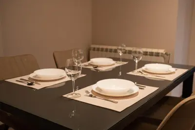 a table with plates and wine glasses on it at Family & Friends Apt, Skadarlija in Belgrade