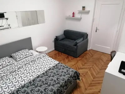 a bedroom with a bed and a chair at Belgrade apartment Bulevar II in Belgrade