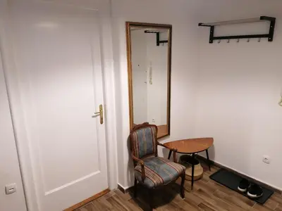 a room with a chair and a mirror and a table at Belgrade apartment Bulevar II in Belgrade